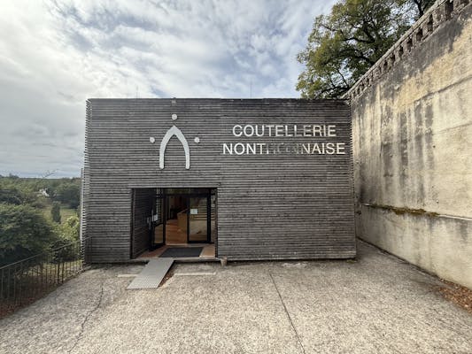 The entrance to the Coutellerie Nontronnaise - a striking wooden plank frontage showing the name and the iconic Nontron arch logo.