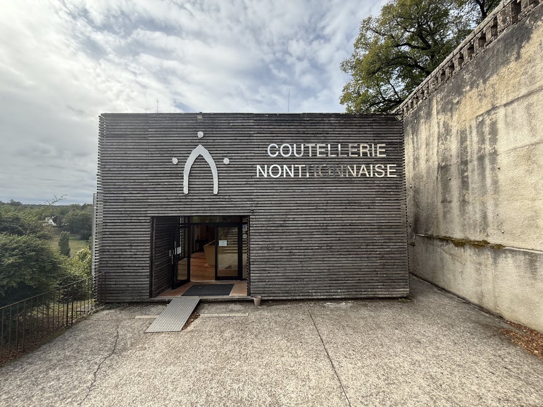 The entrance to the Coutellerie Nontronnaise - a striking wooden plank frontage showing the name and the iconic Nontron arch logo.