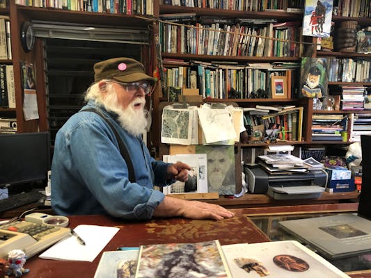 Proprietor Michael behind his desk, covered in Bigfoot paraphernalia