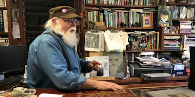 Proprietor Michael behind his desk, covered in Bigfoot paraphernalia