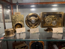 A gallery of old wooden display cabinets with black and white photos lining the wall.