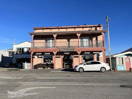A two story orange-pink-brown building with a sign that says Shakespeare Socity of America, New Shakespeare Sanctuary