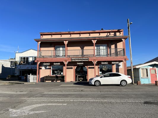 A two story orange-pink-brown building with a sign that says Shakespeare Socity of America, New Shakespeare Sanctuary